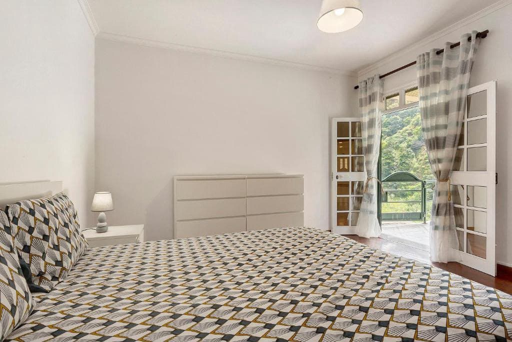 Chambre spacieuse avec lit double et porte-fenêtre sur le balcon