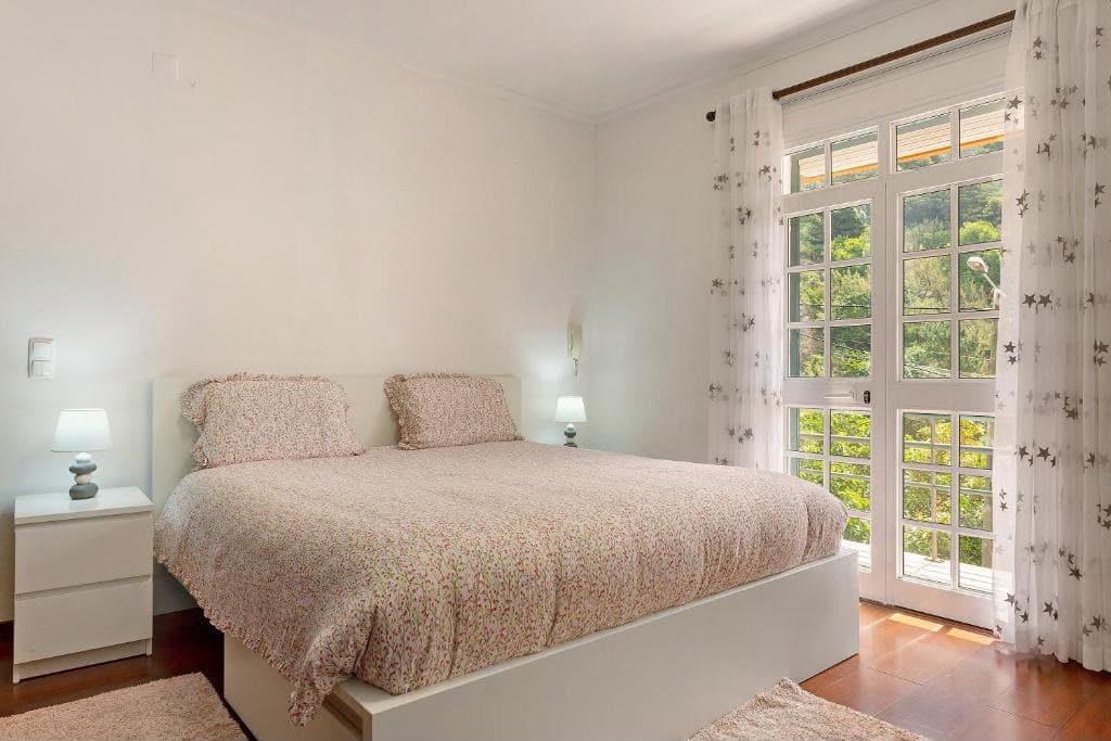 Chambre avec lit double et porte-fenêtre donnant sur la terrasse