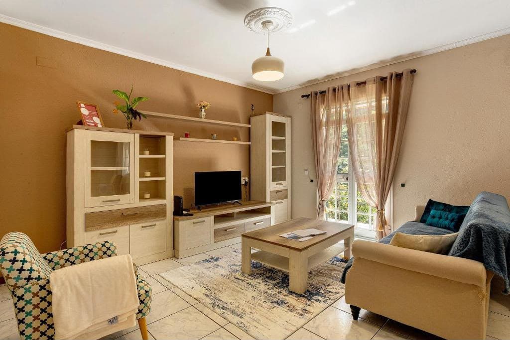 Salon avec canapé, fauteuil et téléviseur